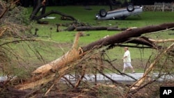 A man walks along the Blanco River where sweeping flood waters overturned vehicles and knocked down trees in Wimberley, Texas, May 26, 2015.