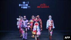 Para model memperagakan busana koleksi Leaf Xia colorwonderland rancangan Xia Yiqi dalam Pekan Mode China di Beijing, 25 Maret 2021. (Foto: STR / AFP)