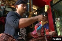 Pupil of Iskandar and Puppeteer, Jamaluddin Syam makes a puppet, Bogor, West Java Province, Indonesia, Aug. 25, 2019