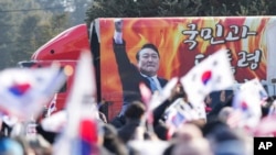 Gambar Presiden Korea Selatan yang dimakzulkan, Yoon Suk Yeol, terpampang di sebuah kendaraan dalam demo untuk menentang pemakzulannya di luar rumah tahanan di Uiwang, Korea Selatan, Jumat, 17 Januari 2025. (Foto: Lee Jin-man/AP Photo)