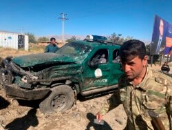 FILE - Afghan police inspect the site of a suicide attack, in Parwan province of Afghanistan, Sept. 17, 2019.