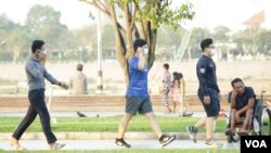 Cambodian residents wearing face masks walk on a street in Phnom Penh, Cambodia, on March 15, 2021. (Hean Socheata/VOA Khmer)