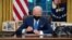 FILE - US President Joe Biden signs executive orders related to immigration in the Oval Office of the White House in Washington, DC, February 2, 2021. (Photo by SAUL LOEB / AFP)