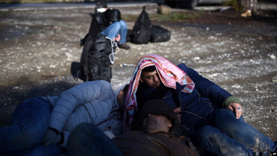 Syrian refugees wait to be picked up by the police on the outskirts of the northern Greek city of Thessaloniki, Nov. 30, 2016. 