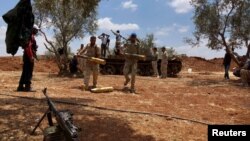 FILE - Free Syrian Army fighters prepare their ammunition during what they said was an offensive against forces loyal to Syria's President Bashar al-Assad in the southern city of Dara'a. 