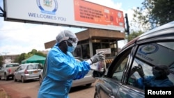 Un agent de santé distribue du gel antibactérien pour empêcher la propagation de la maladie à coronavirus (COVID-19) à l'extérieur d'un hôpital de Harare, Zimbabwe, le 26 mars 2020.