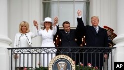 Presiden Donald Trump, Presiden Perancis Emmanuel Macron, ibu negara Melania Trump dan Brigitte Macron berpegangan tangan di balkon Gedung Putih dalam Upacara Penyambutan Tamu Negara di Gedung Putih di Washington, D.C., 24 April 2018. 