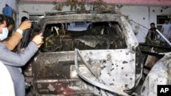 ڕۆژنامەنووسە ئەفغانیەکان وێنەی ئەو ئوتومبێلە دەگرن کە فڕۆکە بێفڕۆکەوانەکەی ئەمەریکا کردییە ئامانج