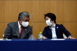 President of the Tokyo 2020 Olympics Organizing Committee Seiko Hashimoto (R) speaks with Tokyo 2020 Vice Director-General Yukihiko Nunomura (L) before the press briefing on operation and media coverage of Olympic Torch Relay in Tokyo, Feb. 25, 2021.