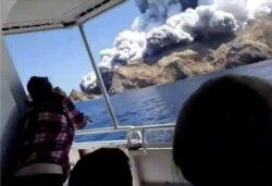 People on a boat react as smoke billows from the volcanic eruption of Whakaari, also known as White Island, New Zealand, Dec. 9, 2019 in this picture grab obtained from a social media video. (INSTAGRAM @ALLESSANDROKAUFFMANN/via Reuters)