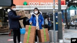 People leave after buying face masks at a pharmacy in Seoul, South Korea, Jan. 29, 2020. 
