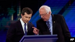 Democratic presidential candidates South Bend Mayor Pete Buttigieg, left, and Sen. Bernie Sanders talk during a break, Sept. 12, 2019, during a Democratic presidential primary debate in Houston.