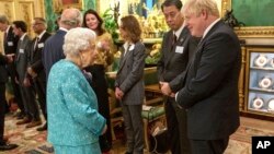 Britain's Queen Elizabeth II talks with Britain's Prime Minister Boris Johnson, right, at a reception for the Global Investment Summit in Windsor Castle, Oct. 19, 2021. (Arthur Edwards/Pool via AP)