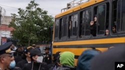 Mujeres y niños que integran la extremista secta ultraortodoxa judía Lev Tahor gritan por su libertad desde un autobús tras quedar bajo custodia después de que la policía los rescatara tras una denuncia de abuso, en Ciudad de Guatemala, el lunes 23 de diciembre de 2024.