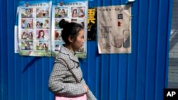 중국 베이징 시내에 붙어있는 외국인 간첩에 대한 경고 포스터 앞으로 시민이 걸어가고 있다. (자료사진)