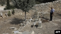 Father Antonio Scudu, caretaker of Saint Stephen Church in the Beit Jamal Salesian monastery, looks at overturned crosses in a graveyard that has reportedly been vandalised near the central Israeli town of Beit Shemesh, west of Jerusalem, Oct. 18 2018. 