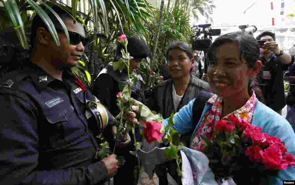 Pro-army supporters hand roses to police officers guarding the Australian embassy in Bangkok, June 4, 2014. 