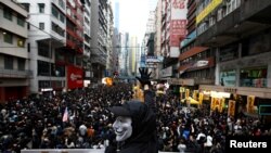 An anti-government protester wearing a Guy Fawkes mask takes part in a demonstration during New Year's Day to call for better governance and democratic reforms in Hong Kong, China, Jan. 1, 2020. 