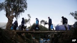 Migrantes se dirigen a un campamento improvisado junto al campamento de Moria, en la isla de Lesbos, Grecia, el 15 de noviembre de 2019. 