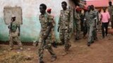 FILE -South Sudanese soldiers accused of a horrific attack on foreign aid workers including rape, torture, killing and looting on the Terrain hotel compound, are assisted to a prison van after attending their trial in Juba, South Sudan.