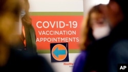 FILE - A COVID-19 vaccination appointments sign points the way at Edward Hospital in Naperville, Illinois, Dec. 17, 2020. 