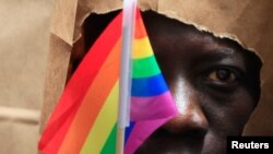 FILE - An asylum seeker from Uganda covers his face with a paper bag to protect his identity as he marches with the LGBT Asylum Support Task Force during the Gay Pride Parade in Boston, Massachusetts, June 8, 2013.