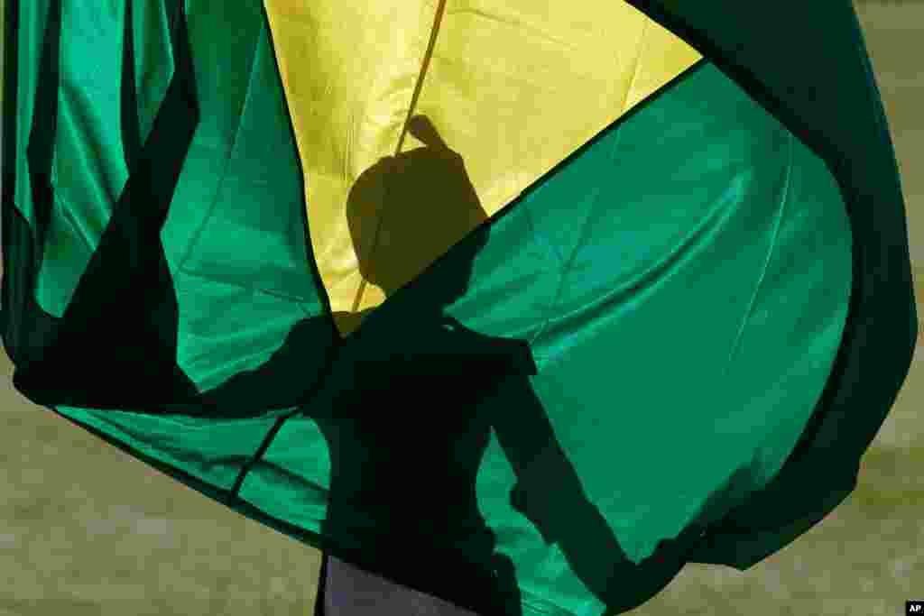 A soldier holds the Brazilian flag during the flag-raising ceremony at the Alvorada Palace, in Brasilia, Brazil.