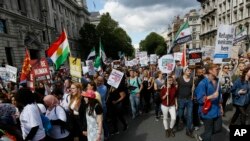 Para demonstran membawa poster dalam pawai solidaritas untuk pengungsi dari Marble Arch ke Parlemen di London, Sabtu, 12 September 2015.