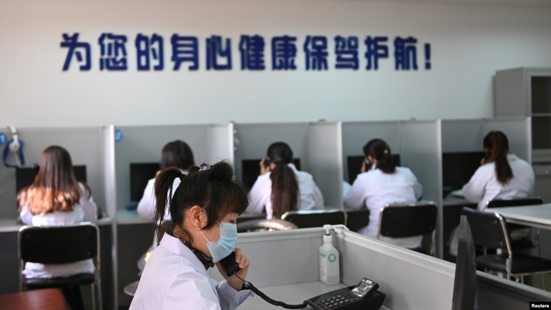 中國遼寧省沈陽市精神健康熱線電話服務站裡戴著口罩的輔導人員為打來求助電話的人提供幫助。（2020年2月12日）