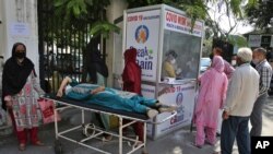 Health workers check rapid test kits after taking nasal swab samples at a COVID-19 testing center in Hyderabad, India, Oct. 11, 2020.