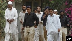 Pakistani police officers escort troops of a paramilitary force to an anti-terrorist court to face charges in the June shooting death of an unarmed man in Karachi, Pakistan, Aug. 12, 2011.