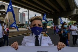 Empleados de Copa Airlines participan en una protesta contra la presunta corrupción y el hambre en medio de la nueva pandemia de coronavirus fuera de la Asamblea Nacional en la Ciudad de Panamá, el 1 de julio de 2020.