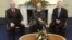 In this image released by Northern Ireland Government Assembly, showing US Secretary of State Hillary Rodham Clinton, centre, sitting with First Minister Peter Robinson, right, and deputy First Minister Martin McGuinness, as they pose together in Belfast 