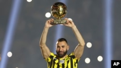 FILE - Saudi Arabia based French football star Karim Benzema holds the Ballon d'Or 2022 trophy during his presentation ceremony to his new club Al Ittihad at King Abdullah Sports City Stadium in Jeddah, Saudi Arabia, June 8, 2023.