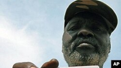 A former Sudanese militia fighter holds up his new identity card in the town of Al-Damazin, in the Blue Nile province, more than 500 km south of Khartoum, after completing a demilitarization program designed to reintegrate militants into civilian life (fi