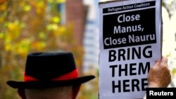 FILE - A protester from the Refugee Action Coalition holds a placard during a demonstration outside the offices of the Australian Government Department of Immigration and Border Protection in Sydney, Australia, April 29, 2016. 