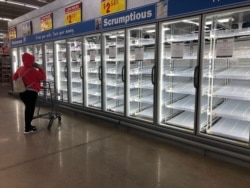 A shopper at an H-E-B Plus! supermarket faces empty shelves in the Flour Bluff neighborhood of Corpus Christi, Texas, Feb. 18, 2021.