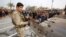 A member of the Iraqi security forces stands guard as worshippers conduct open-air Friday prayers in Baghdad's Sadr City, Iraq, Oct. 30, 2015.