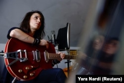 Lebanese singer and musician Joy Fayad holds her guitar in her studio in Mazraat Yachouh, Lebanon November 6, 2024. (REUTERS/Yara Nardi)