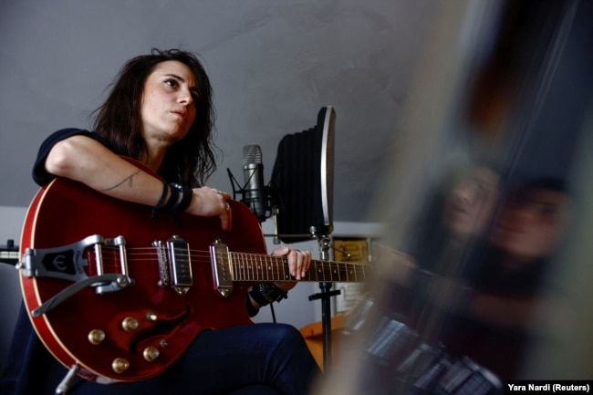 Lebanese singer and musician Joy Fayad holds her guitar in her studio in Mazraat Yachouh, Lebanon November 6, 2024. (REUTERS/Yara Nardi)