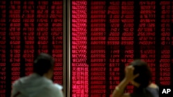 Chinese investors monitor stock prices at a brokerage house in Beijing, Aug. 2, 2019. 