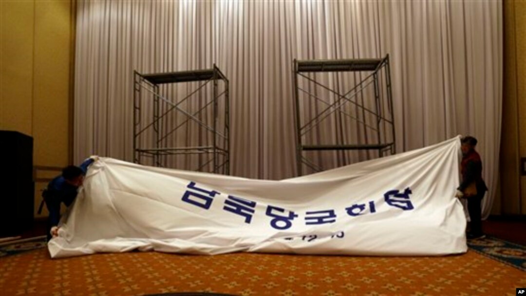 Pekerja Korea Selatan membongkar papan nama di tempat yang semula akan digunakan untuk pertemuan tingkat tinggi pertama Korea di Hotel Grand Hilton di Seoul, Korea Selatan (12/6).