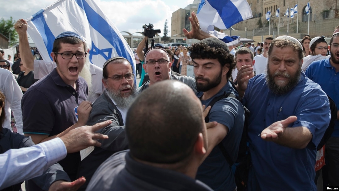Israeli right-wing activists confront a security official near the Western Wall inside the old city of Jerusalem, Oct. 30, 2014. 