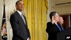  President Barack Obama listens as Homeland Security Secretary Janet Napolitano delivers the oath of allegiance during a naturalization ceremony for active duty service members and civilians, in the East Room of the White House in Washington, March 25, 20