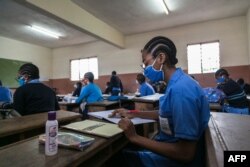 Students wear face masks as a preventive measure against the spread of the COVID-19 coronavirus in their classroom at the Jean Benoit College in Yaoundé, Cameroon, on June 1, 2020.
