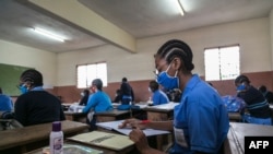 Students wear face masks as a preventive measure against the spread of the COVID-19 coronavirus in their classroom at the Jean Benoit College in Yaoundé, Cameroon, on June 1, 2020. 