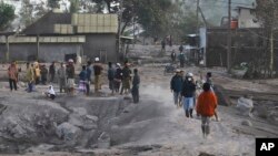 People inspect their ash-covered village following the eruption of Mount Semeru in Lumajang, East Java, Indonesia, Monday, Dec. 5, 2022.