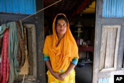 Monira Khatun, 29, stands by the door of her house in Chila Bazar, in Mongla, Bangladesh, March 4, 2022. (AP Photo/Mahmud Hossain Opu)
