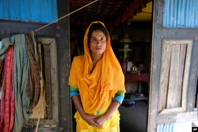 Monira Khatun, 29, stands by the door of her house in Chila Bazar, in Mongla, Bangladesh, March 4, 2022. (AP Photo/Mahmud Hossain Opu)