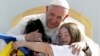 El papa Francisco abraza a dos jóvenes con síndrome Down en el estadio José María Pavón de Morelia.